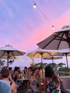 a group of people sitting at tables under umbrellas at Ceylon Sliders in Weligama +52 photos
