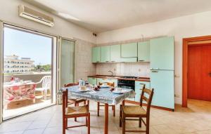 a kitchen with a table and chairs and a kitchen with green cabinets at Residence Ionian Gallipoli in Gallipoli