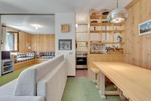 ein Wohnzimmer mit einem Sofa und einem Tisch in der Unterkunft Santa Caterina Isola Apartment in Santa Caterina Valfurva