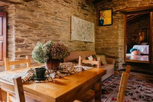 una mesa de comedor con un jarrón de flores. en Casas de Outeiro, en Samos