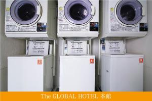 The Global Hotel Tokyo في طوكيو: أربعة غسالات ومجففات تصطف على الحائط