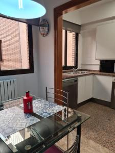 a kitchen with a glass table and a counter top at Dos Torres Ático Dúplex - Céntrico con Vistas a la Ciudad in Zaragoza