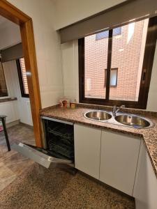 una cocina con 2 lavabos y una ventana en Dos Torres Ático Dúplex - Céntrico con Vistas a la Ciudad, en Zaragoza