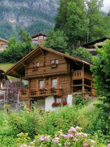 a wooden house with flowers in front of it at B & B Brienz in Brienz