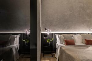 una camera con tre letti con cuscini di Corso 84 Luxury Suites a Pescara