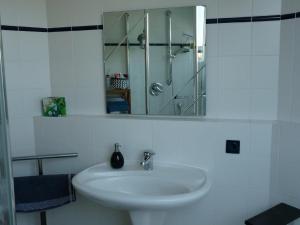 a white bathroom with a sink and a mirror at Ferienwohnung Natur pur in Bad Pyrmont