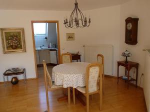 a dining room with a table and chairs and a clock at Ferienwohnung Natur pur in Bad Pyrmont