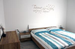 una camera da letto con un letto con un tavolo in legno e un cartello sul muro di Appartement Michelle a Neusiedl am See