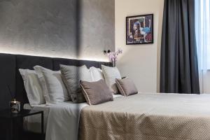 a bedroom with a large bed with white pillows at Corso 84 Luxury Suites in Pescara