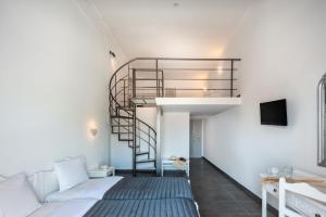 a spiral staircase in a living room with a couch at Rivari Santorini Hotel in Kamari