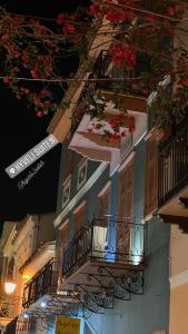 un edificio con 2 balcones y flores. en Kyveli Suites, en Nauplia