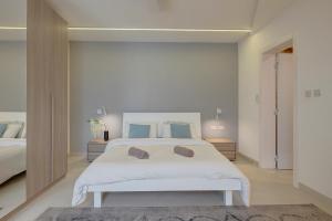 a bedroom with a large white bed with blue pillows at Stunning Apartment in a Central Location with Views in Taʼ Xbiex