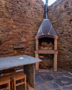 un mur en briques avec un four à pizza extérieur dans l'établissement Casas de Outeiro, à Samos