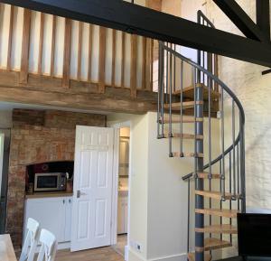 una escalera que conduce a un loft reconvertido en Garden Barn, en Farthinghoe