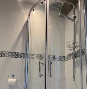 a bathroom with a shower with a glass door at Garden Barn in Farthinghoe