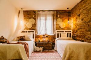 une chambre avec deux lits et une fenêtre dans l'établissement Casas de Outeiro, à Samos