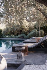 um pátio com uma mesa e cadeiras ao lado de uma piscina em Opora Country Living em Nafplio