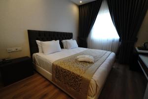 Un pat sau paturi într-o cameră la The Green Park Diyarbakir