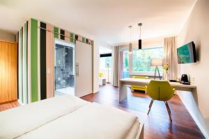 a bedroom with a bed and a desk and a chair at Hotel Carolinenhof in Berlin