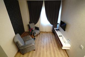 an overhead view of a living room with a chair and a television at The Green Park Diyarbakir in Diyarbakır