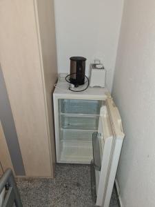 an empty refrigerator with a pot on top of it at Privater Eingang mit Fußbodenheizung und Swimmingpoolblick - Ruhe und Erholung garantiert in Troisdorf