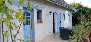 una casa con porte blu e un patio di Chez Sophie et Thibault a Sceaux-du-Gâtinais