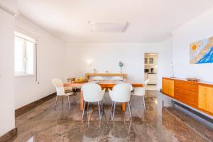 uma sala de jantar com uma mesa e cadeiras brancas em Povoa Sunset Views na Póvoa do Varzim mais 37 fotografias