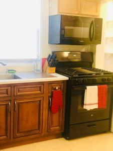 uma cozinha com um fogão preto e um micro-ondas em Lovely old family home em Rochester