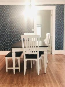 uma sala de jantar com uma mesa branca e cadeiras em Lovely old family home em Rochester