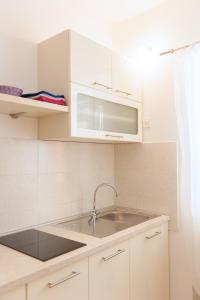 a kitchen with a sink and a microwave at Dalmatian Garden - FREE parking - city centre in Šibenik +20 photos