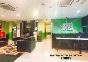 a room with a table and a couch and a desk at Sastria Hotel Sungai Petani in Sungai Petani