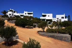 een groot wit gebouw met bomen ervoor bij Onar Studios in Koufonisia