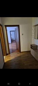 um quarto vazio com uma porta e um piso de madeira em Apartament Maria em Turda