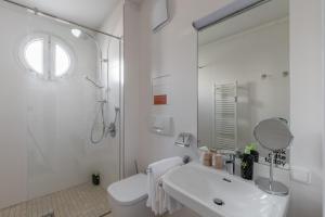 a white bathroom with a sink and a shower at limehome Linz Friedrichstraße in Linz