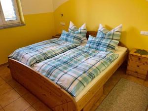 uma cama com lençóis e almofadas azuis e brancos em Haus Fernblick em Waldkirchen