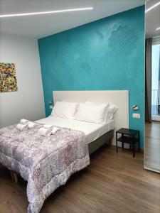 a bedroom with a bed and a blue wall at Luxury B&B Iolanda in Catania