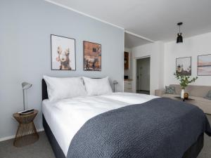 una camera da letto con un grande letto con lenzuola bianche di limehome Linz Friedrichstraße a Linz