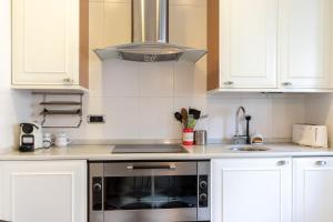 a kitchen with white cabinets and a stove top oven at Bilbao Costa by Aston Rentals in Getxo