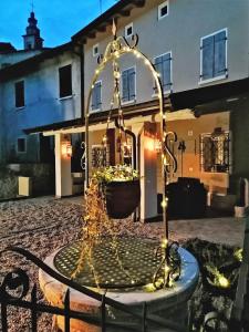 una fontana di fronte a una casa con luci di Residenza al Castello a Castellaro