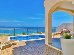 a villa with a swimming pool and a view of the ocean at Luxury Villa Akti Barbati 1 with private pool in Ano Pyrgi