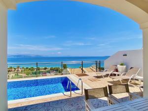 a villa with a swimming pool and a view of the ocean at Luxury Villa Akti Barbati 1 with private pool in Ano Pyrgi
