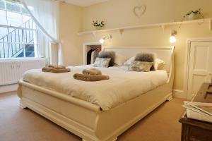 Un dormitorio con una gran cama blanca con animales de peluche. en Southcot Place, en Bath