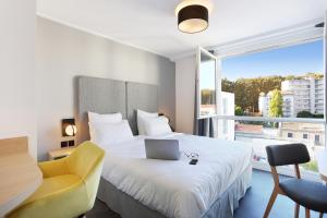 a bedroom with a bed with a laptop on it at Appart Hotel Odalys City Toulouse Centre Compans Caffarelli in Toulouse