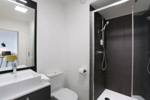 a bathroom with a shower and a toilet and a sink at Appart Hotel Odalys City Toulouse Centre Compans Caffarelli in Toulouse