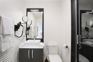 a bathroom with a sink and a toilet and a mirror at Appart Hotel Odalys City Toulouse Centre Compans Caffarelli in Toulouse