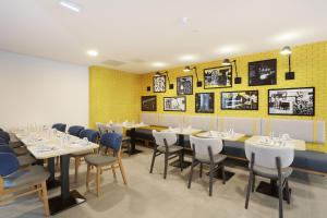 a dining room with tables and chairs and yellow walls at Appart Hotel Odalys City Toulouse Centre Compans Caffarelli in Toulouse