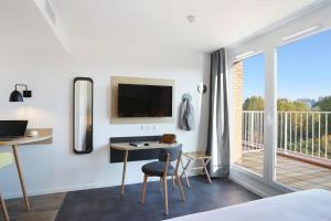 a bedroom with a bed and a desk and a tv at Appart Hotel Odalys City Toulouse Centre Compans Caffarelli in Toulouse