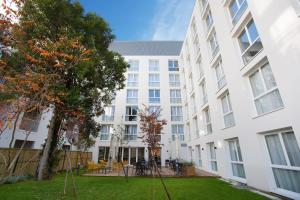 an apartment building with a lawn in front of it at Appart Hotel Odalys City Toulouse Centre Compans Caffarelli in Toulouse