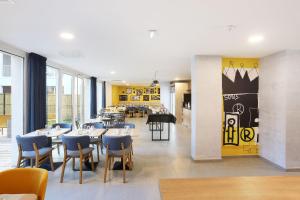a dining room with tables and chairs and a restaurant at Appart Hotel Odalys City Toulouse Centre Compans Caffarelli in Toulouse