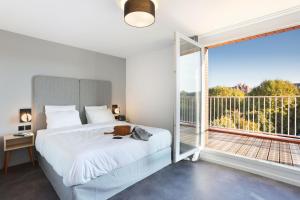 a bedroom with a bed and a large window at Appart Hotel Odalys City Toulouse Centre Compans Caffarelli in Toulouse